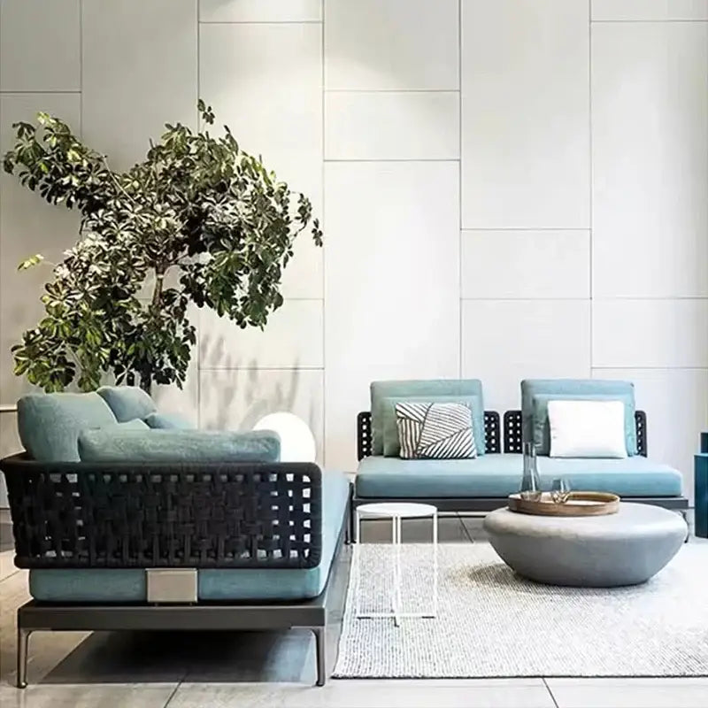 Modular L-shaped outdoor rattan sofa set featuring woven rattan material with plush cushions and aluminum frame detail.